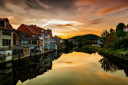 body of water beside concrete houses under cloudy sky thumbnail