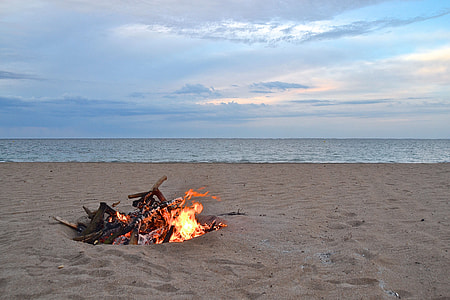 bonfire beside body of water during dawn thumbnail