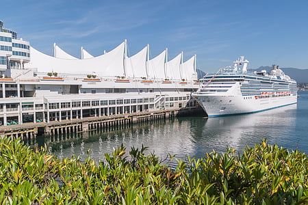 cruise ship on body of water beside building during daytime thumbnail