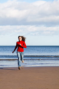woman wearing red long-sleeved shirt running on beach thumbnail