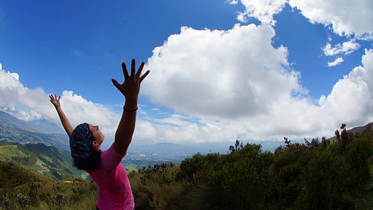 woman raising her hand at the mountain top thumbnail