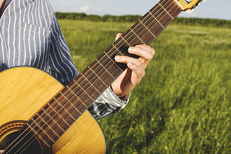 person playing brown acoustic guitar thumbnail