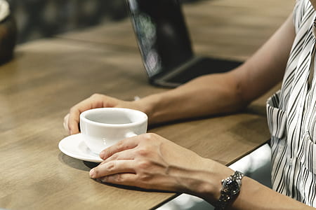 person holds white ceramic teacup thumbnail
