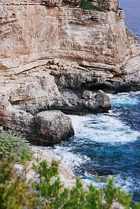 brown cliff beside body of water thumbnail