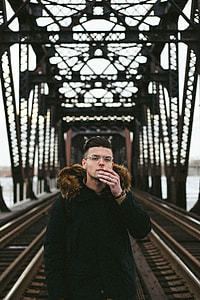 man standing on bridge during daytime thumbnail