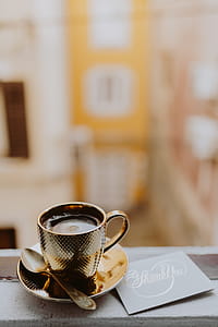 Drink coffee in a golden cup at the window thumbnail