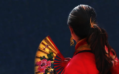 woman' holding floral folding hand fan thumbnail