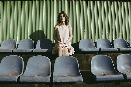 woman wearing white dress sitting on gray chair thumbnail