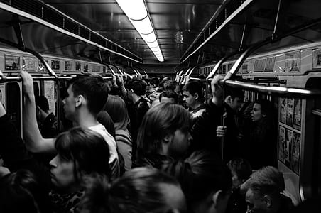 grayscale photography of people standing inside the train thumbnail