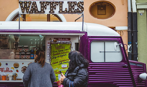 two women standing in front of waffles food truck thumbnail