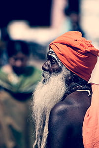 selective focus photo of long bearded man wearing orange turban thumbnail