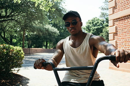Man in White Tank Top Riding on Bicycle thumbnail