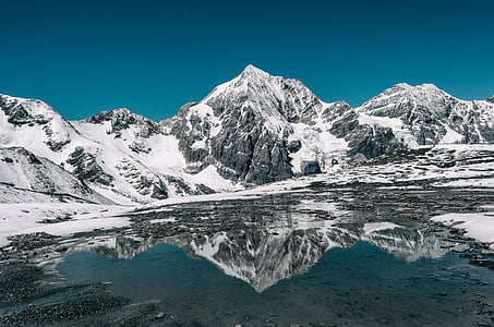 landscape photo of snow covered mountain under blue sky thumbnail