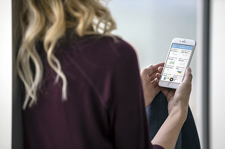 women in purple top holding iPhone thumbnail