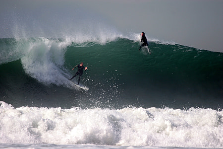 two man surfing on big beach wave during daytime thumbnail