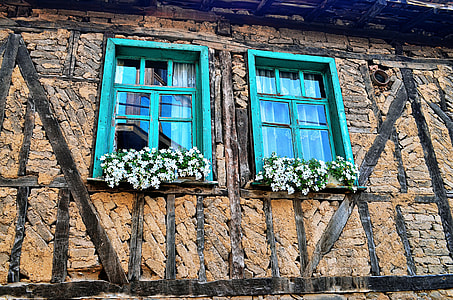 beige bricked building with teal wooden windows thumbnail