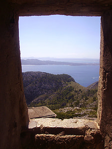 hills covered with trees beside ocean under blue sky during daytime thumbnail