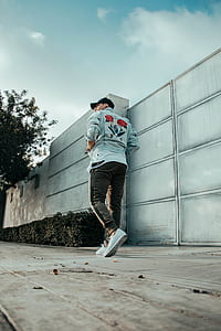 man walking near gray metal gate at daytime thumbnail
