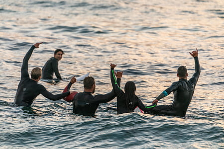 five people on body of water raising their hands mid air photo thumbnail
