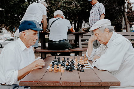 two grandfather playing chess on table thumbnail