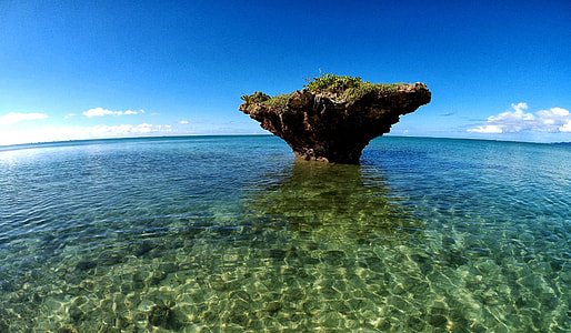 brown stone formation in the middle of body of water thumbnail
