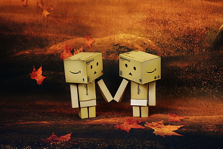 two brown Amazon cardboard robots close up photo thumbnail