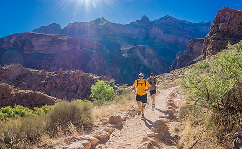 two man running on brown mountains thumbnail