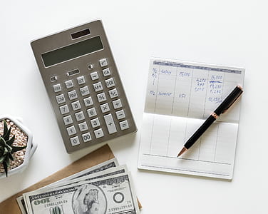 gray desk calculator beside black twist pen thumbnail