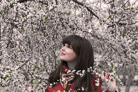 woman in red coat standing near trees thumbnail