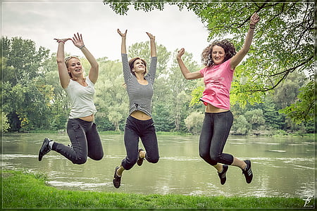 three woman jumping near river thumbnail