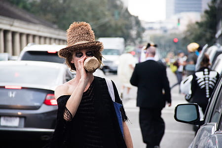 woman standing beside car drinking on bottle thumbnail