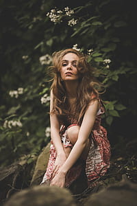 woman sitting on brown rock in forest thumbnail