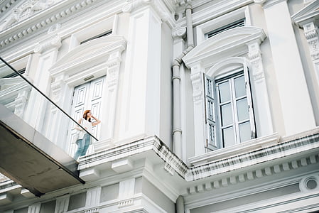 low angle photo of woman standing in front of white building thumbnail
