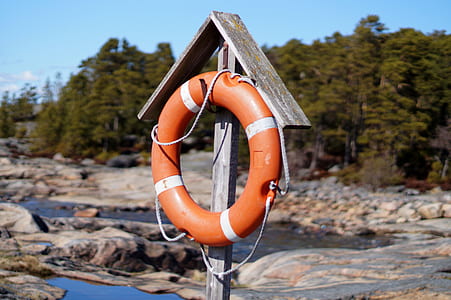 orange life ring hanged on brown hook thumbnail