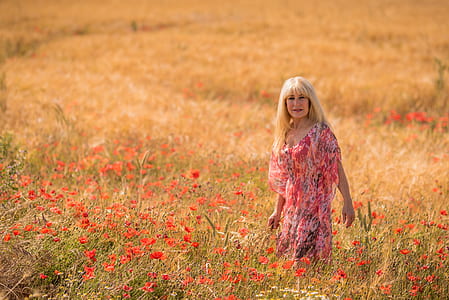 woman in pink dress standing on pink flowers thumbnail