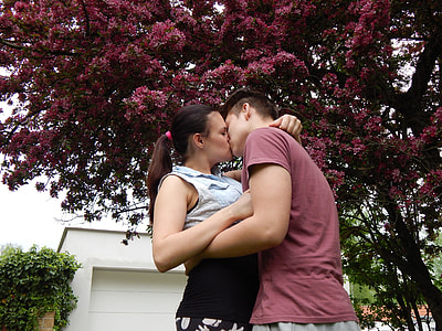 couple kissing under purple leafed tree during daytime thumbnail