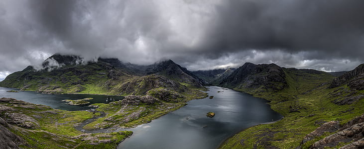 aerial shot of mountains and body of water under cumulus clouds thumbnail
