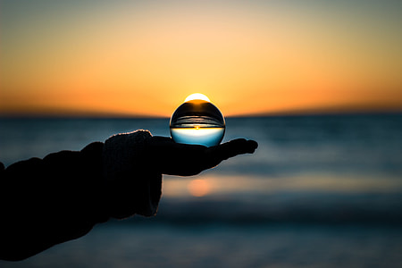 silhouette photo of person holding glass ball thumbnail