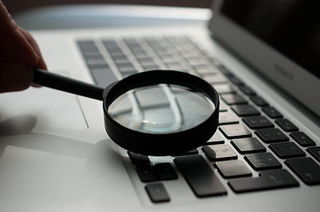 person magnifying MacBook keys thumbnail