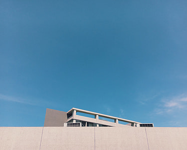 white concrete building under clear blue sky during daytime thumbnail