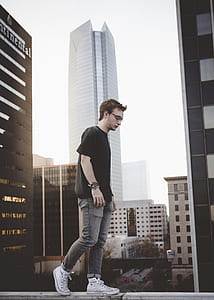 man in black shirt and gray jeans walking on wall thumbnail
