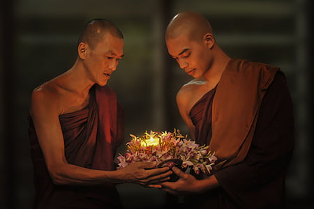 two monks carrying flowers with candle thumbnail