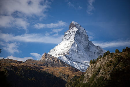 hill under white clouds and blue sky selective photo thumbnail