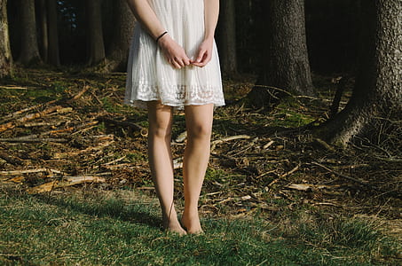 woman wearing white lace midi dress standing on green grass thumbnail