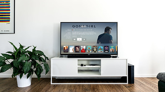 flat screen TV on white wooden stand thumbnail