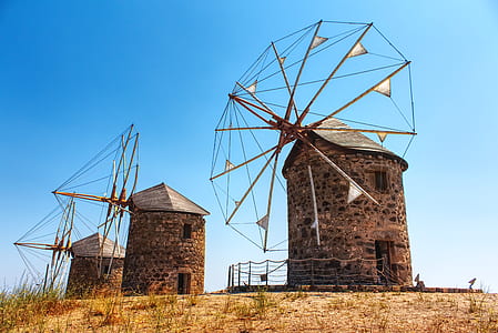 three brown windmills under blue sky thumbnail