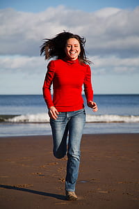 woman running near sea at daytime thumbnail