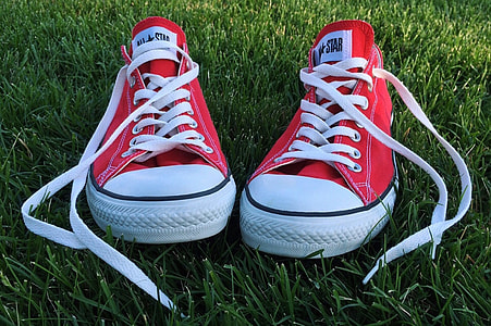 pair of red-and-white Converse All-Star low on green grassfield thumbnail