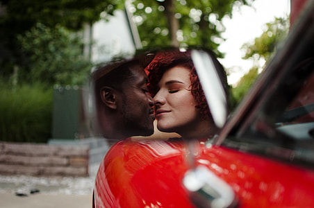 selective photo of couple kissing on the side mirror view thumbnail