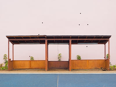 brown and black wooden shed in front of white wall thumbnail